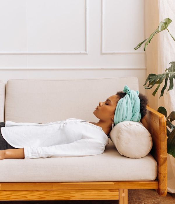 Woman in a calm, focused yoga pose, surrounded by a soft lavender glow.